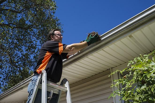 experienced contractor repairing a gutter system in Estell Manor